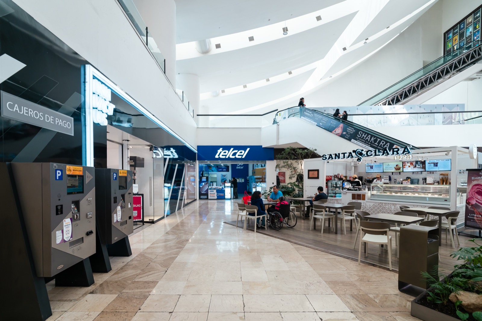 Vista del segundo piso y exteriores de Plaza Universidad con pasillos iluminados y tiendas